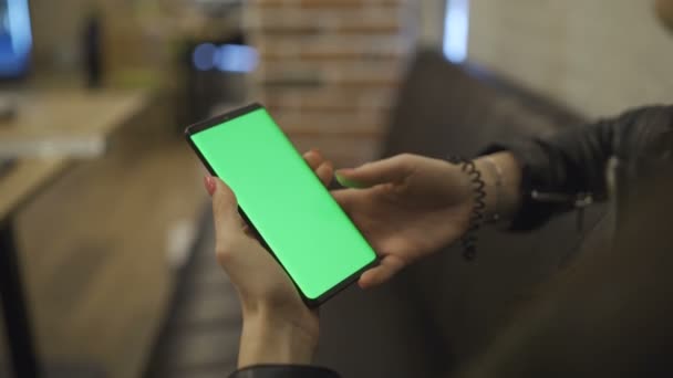 Weibliche Hand scrollt in Handy-App mit Smartphone mit grünem Bildschirm — Stockvideo