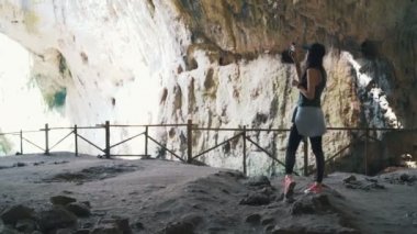 Turist kadın nefes kesici Devetashka mağarası, Bulgaristan 'daki büyük karst mağarası fotoğrafları çekiyor.