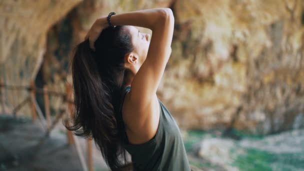 Вмістити жінку фіксуючи волосся закритими очима, насолоджуючись сонячними променями — стокове відео