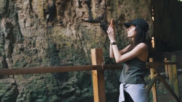 Chica turística tomando fotos de la cueva Devetashka en Bulgaria, mientras que en viaje de vacaciones — Vídeos de Stock