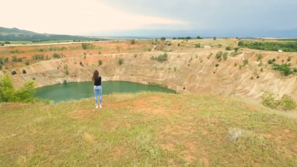 Mulher solitária tirando fotos de mina aberta poço cheio de água azul na aldeia de Tsar Asen, Bulgária — Vídeo de Stock