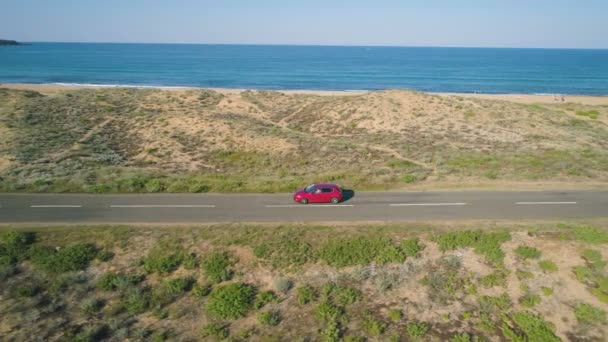 Carro vermelho dirigindo em uma estrada costeira ao longo do Mar Negro — Vídeo de Stock