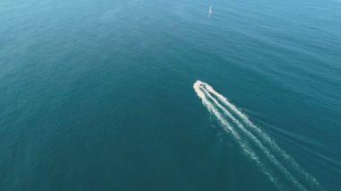 Sakin mavi denizde yüzen beyaz bir teknenin üst görüntüsü. Bulgaristan