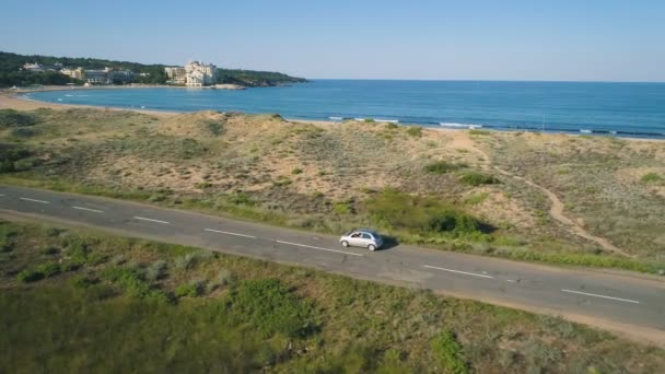 Letecký pohled na auto jízdy na pobřežní silnici vedle krásné divoké pláže — Stock video