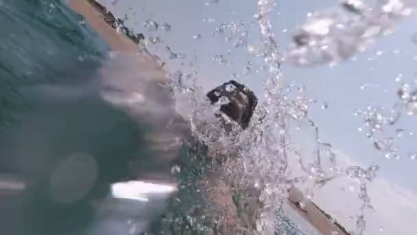 Jonge fitte man met actiecamera tijdens het zwemmen in helder zeewater — Stockvideo