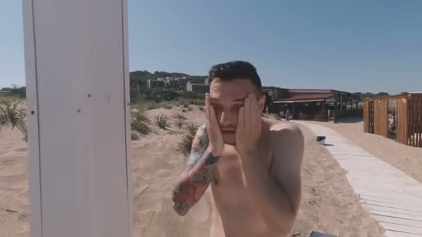 Happy active man biorąc zimny prysznic na plaży, śmiejąc się i bawiąc — Wideo stockowe