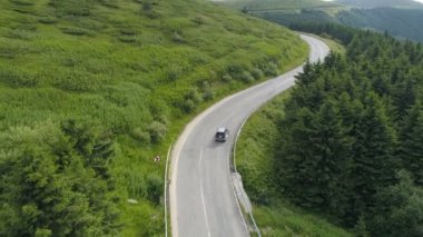 Bulutlu bir günde dağ yolunda giden SUV kamyonu