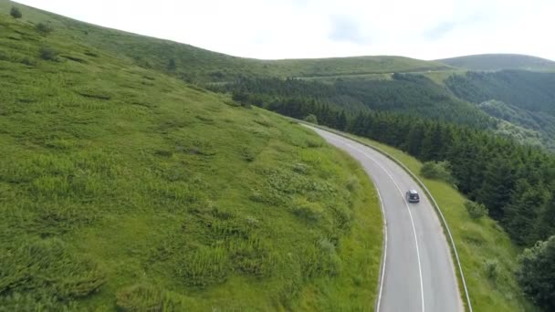 Náklaďák jede na horské dálnici se zelenými kopci a panoramatickým výhledem, odbočuje vlevo — Stock video