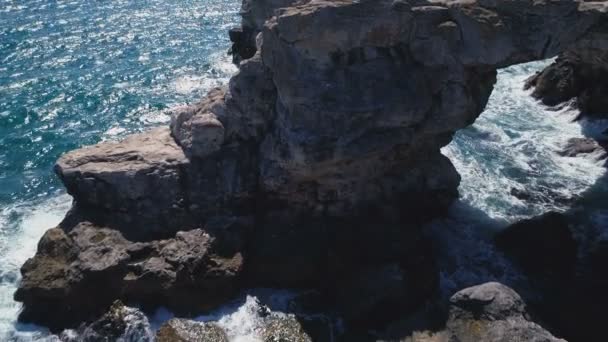 Droni vista dall'alto verso il basso delle onde del mare turchese che si infrangono sull'arco roccioso in mare — Video Stock
