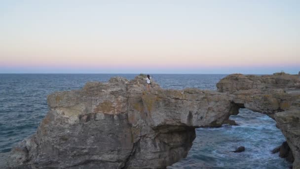 Flygfoto över kvinna som tar bilder sitter på toppen av klippvalv nära byn Tyulenovo i Bulgarien — Stockvideo