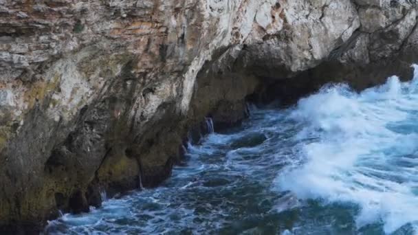 Fröccsenő hullámok sziklák ellen a bolgár tengerparton egy gyönyörű napos nyári reggelen — Stock videók