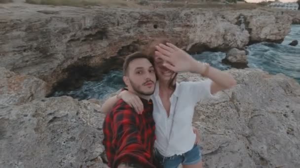 Szczęśliwa para filmująca siebie na wybrzeżu. Kobieta wysyłając pocałunek powietrza do kamery i machając — Wideo stockowe