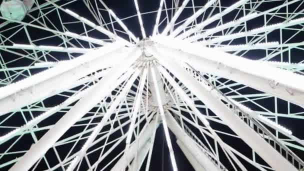 Vista inferior de la rueda de la fortuna girando y luces blancas intermitentes en la noche — Vídeos de Stock