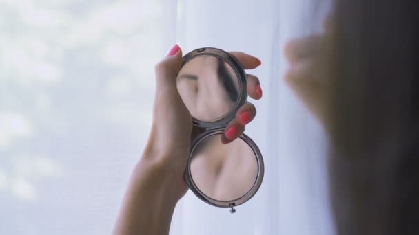 Närbild av Kvinna reflektion i en fickspegel, applicera puder makeup med hjälp av en borste — Stockvideo