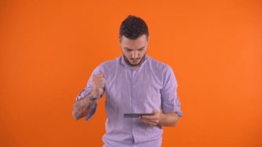 Akıllı telefondan maç izlerken futbol takımının çığlıkları ve sevinç dolu galibiyetleri, izole edilmiş mandalina renginde bahis konseptleri