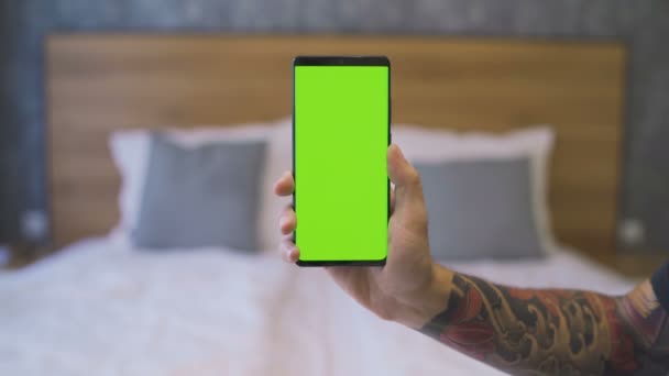 Muž držící černý mobilní telefon se zelenou obrazovkou — Stock video