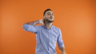 Adam dans ediyor ve gülümsüyor. Yavaş popüler kulüp dansı, saçlara dokunmak ve yüzün önünde hareket eden eller.