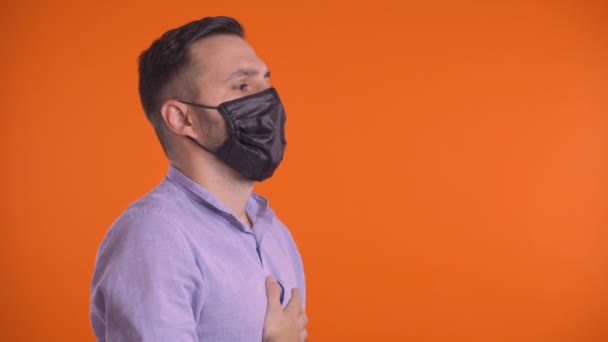 Profile shot of young man taking off face mask and breathing freely. Smiling at camera happy — Stock Video