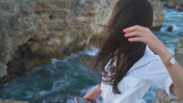 Красива молода жінка з волоссям дме в її обличчя морським бризом — стокове відео