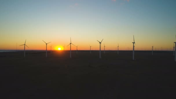 Silhouetten van windturbines die bij zonsondergang energie opwekken in Bulgarije, Zwarte Zeekust — Stockvideo