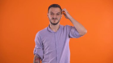 Suçlu, utangaç, kafasını kaşıyan, düşünen, gözlerini deviren bir adam.