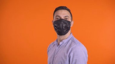 Genç adam dur işareti gösteriyor. Yüz maskeli bir adam dur işareti yapıyor, el sallıyor.