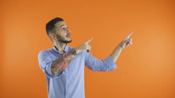 Young casual man presenting something with both hands and a smile on his face — Stock Video