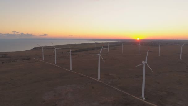 Faszinierende Landschaft mit Meeresküste und Meereshorizont bei Sonnenuntergang und Windrädern zur Erzeugung von Ökoenergie — Stockvideo