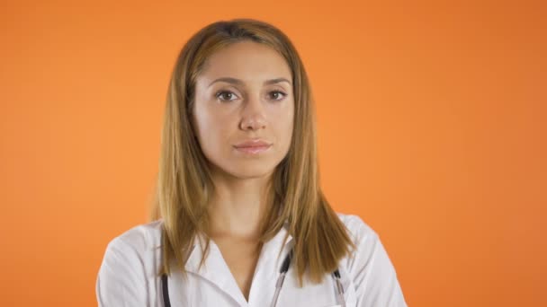 Tiro de perto, Retrato de belas mulheres jovens médico em casaco branco e estetoscópio nos ombros. Estúdio — Vídeo de Stock