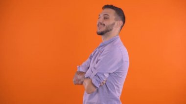 Seksi yakışıklı adam göz kırpıyor ve öpücük gönderiyor. Stüdyo çekimi, turuncu arkaplan kopyalama alanı