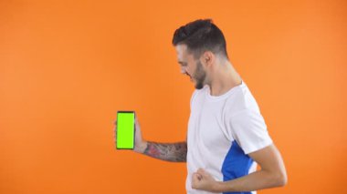 Yeşil ekranlı telefon ile futbol fanatiği Zafer, mutluluk ve gol maç desteğindeki futbol taraftarlarının duygularını haykırıyor