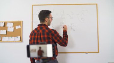 Çevrimiçi matematik öğretmeni kırmızı gömlekli. 