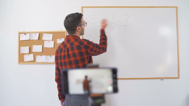 Jovem professor europeu com vidro Live Math Ensino falando na câmera do smartphone — Vídeo de Stock