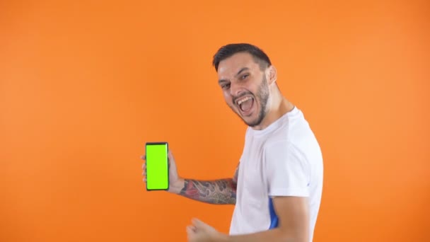 Torcedor de futebol feliz ou jogador celebrando e mostrar telefone tela verde — Vídeo de Stock