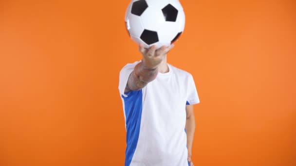 Självsäker ser Fotboll fan eller spelare poserar med fotboll framför ansiktet, sedan hålla den under armen — Stockvideo