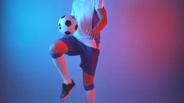 Profesyonel üniformalı futbol, stüdyo kırmızı ve mavi ışıklarda top hokkabazlığı.