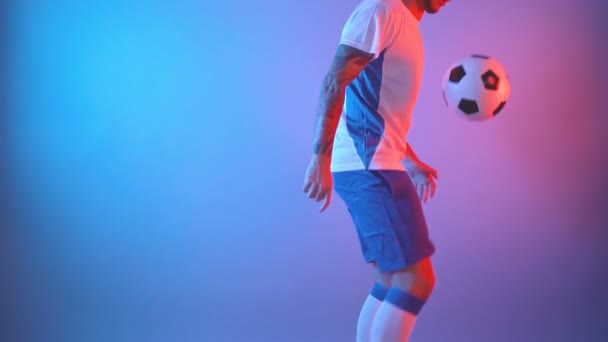 Professionele Europese voetballer jongleren in kleurrijke studio — Stockvideo