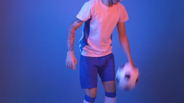 Футболист в белом и синем жонглировании в студии 4k — стоковое видео