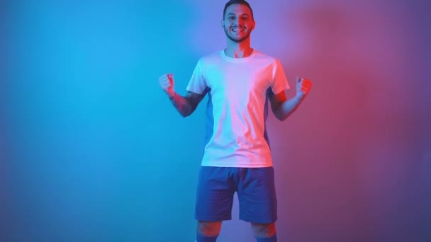 Crazy νεαρός γενειοφόρος οπαδός του ποδοσφαίρου ή παίκτης με λευκό-μπλε πουκάμισο που δείχνει τη χαρά του από τη νίκη — Αρχείο Βίντεο