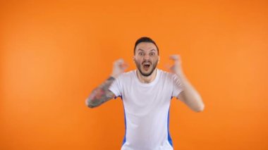 Heyecanlı, ciddi görünüşlü genç adam futbol maçına bahis oynadı, yumruklarını sıktı ve takımı için tezahürat yaptı.