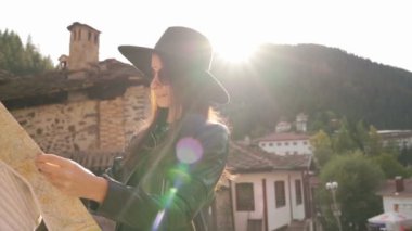 Bulgaristan 'ın Shiroka Laka kentinde turistik haritalı güneş parlayan kız. 