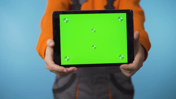 Закрытие планшета с зеленым экраном и рабочего, изолированного в студии — стоковое видео