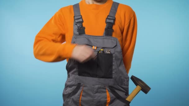 Egy férfi munkaruhában, csavarhúzóval a kezében. — Stock videók