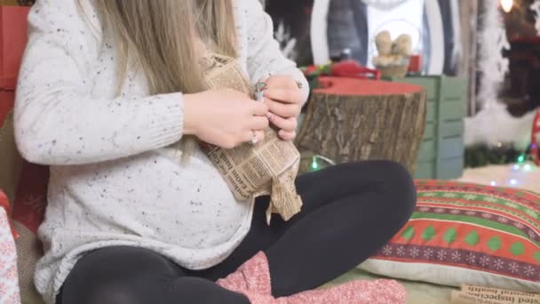 Gravid kvinna packar upp julklappar Indor — Stockvideo