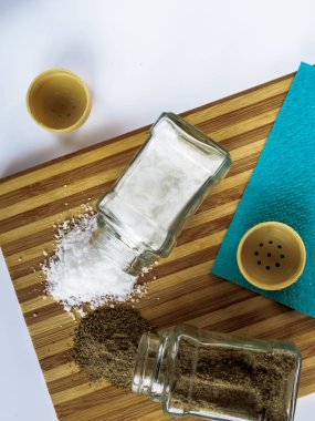 Tuz ve biber saçılan cam tuz shakers ve biber shakers bir kesme tahtası üzerinde