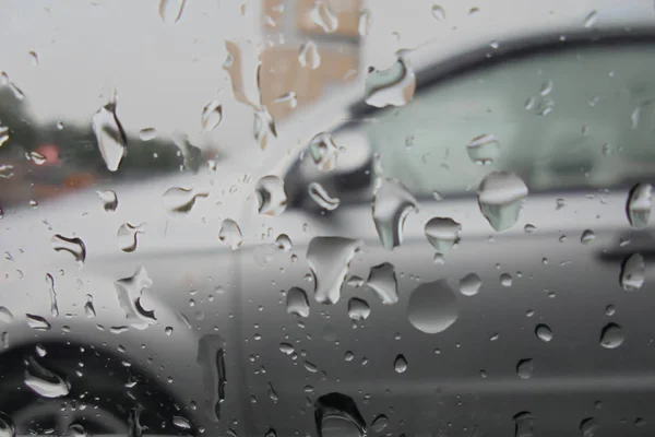 Gocce di pioggia su una vista di vetro di auto da un interno di auto — Foto Stock