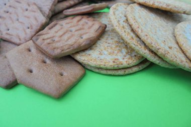 çeşitli bisküvi çeşitleri, kepek ile yuvarlak, çikolata rombik yeşil arka planda yalan