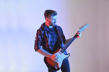 Genç adam izole beyaz arka plan üzerinde gitar çalmak