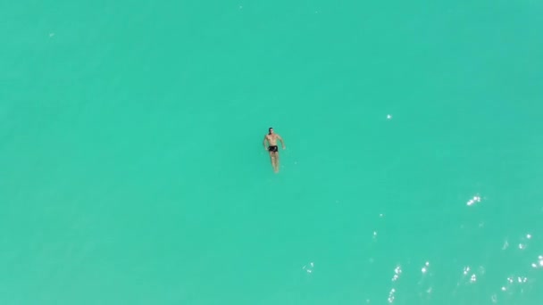 Ένα Νεαρό Αρσενικό Μοντέλο Που Κολυμπάει Μόνο Του Τυρκουάζ Θάλασσα — Αρχείο Βίντεο