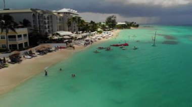 Grand Cayman - Berrak turkuaz su ve palmiye ağaçları ile Ünlü Seven Mile plaj berrak turkuaz su, paddleboards, floatbeds, palmiye ağaçları ve plaj barlar ile güzel ünlü Seven Mile plaj havadan çekim